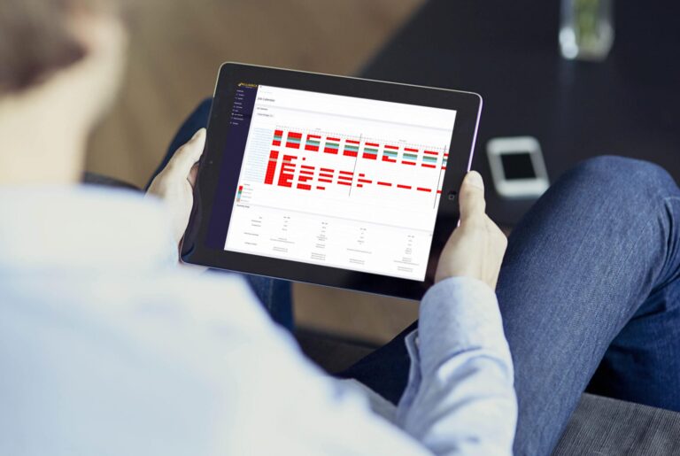Custom software screen mockup for Alliance Roofing's app, shown on a tablet. The tablet is being held by a man in a dress shirt and jeans, sitting on a couch.