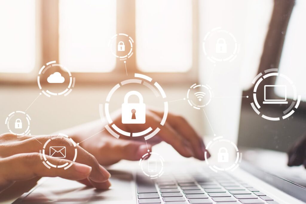 Person typing on keyboard at a home office with digital security icons overlaying the image.